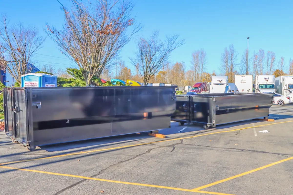Professional dumpster rental service with roll-off container on residential driveway in Phenix City
